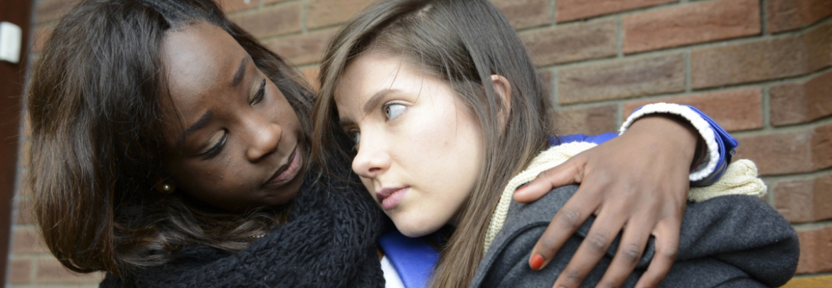 girl being comforted by another woman